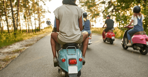 Groepje jonge mensen rijdend op scooters